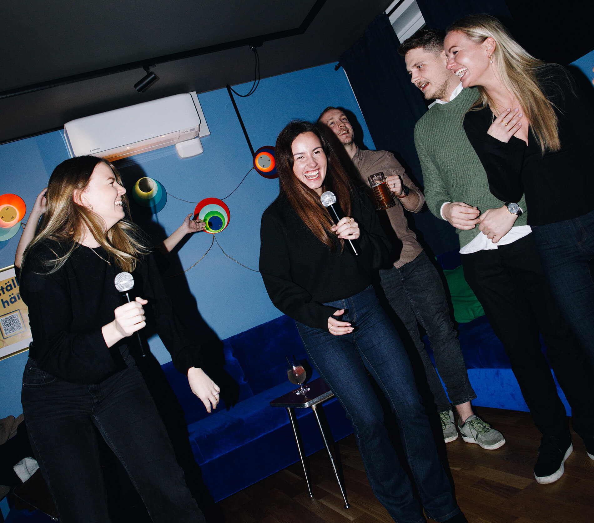 Många glada människor som sjunger karaoke i Malmö på Camping Bar vid Stortorget.